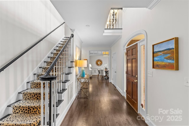 entryway featuring wood finished floors, stairs, and ornamental molding