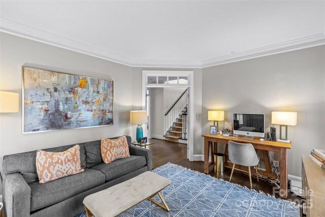 living room with baseboards, wood finished floors, ornamental molding, and stairs