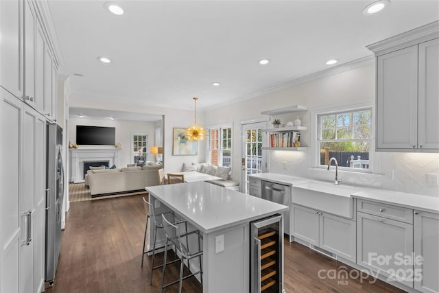 kitchen featuring dark wood-style floors, beverage cooler, ornamental molding, decorative backsplash, and a kitchen bar