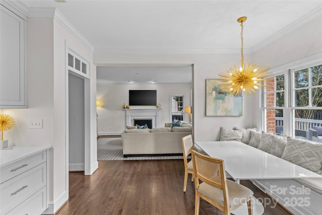 dining space featuring a chandelier, dark wood finished floors, a fireplace, and crown molding