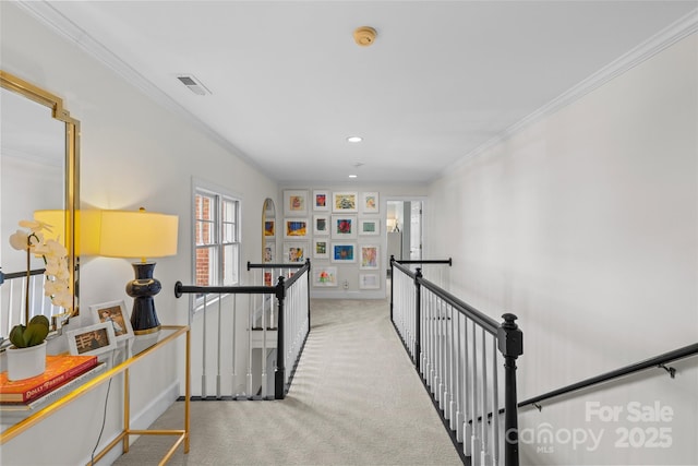 corridor featuring an upstairs landing, visible vents, ornamental molding, and carpet floors