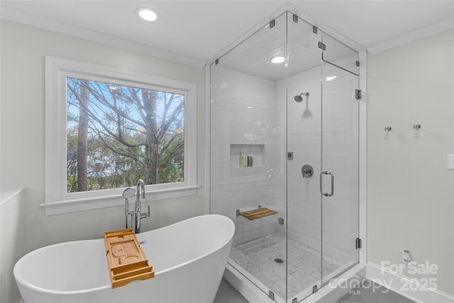 bathroom featuring baseboards, a freestanding bath, a stall shower, and ornamental molding