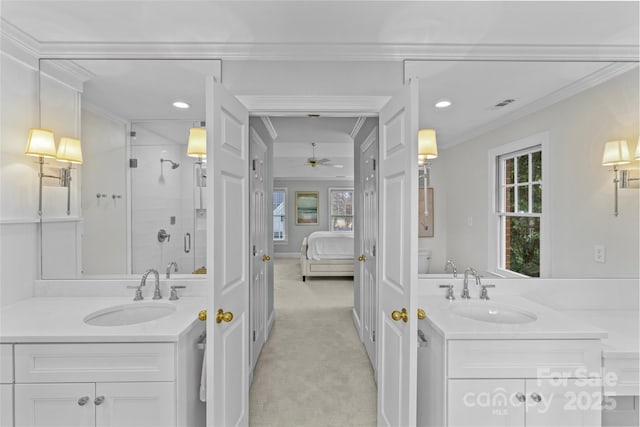 ensuite bathroom with a sink, a stall shower, and crown molding