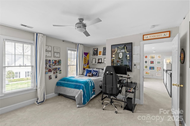 carpeted bedroom with a ceiling fan, baseboards, and visible vents