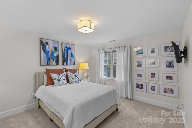 bedroom with baseboards, light carpet, and visible vents