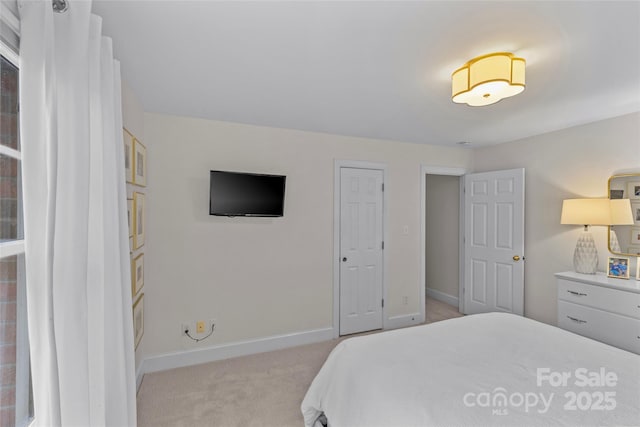 bedroom featuring light carpet and baseboards