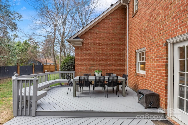 wooden deck with outdoor dining area and fence