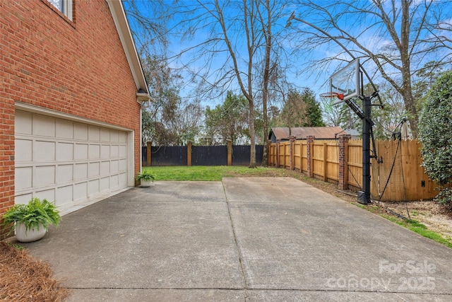 exterior space featuring driveway, a garage, and fence