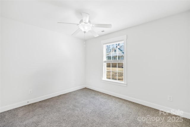 spare room with ceiling fan, carpet floors, visible vents, and baseboards