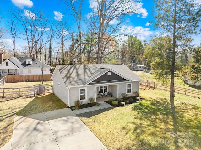 ranch-style house with covered porch, roof with shingles, fence, and a front lawn