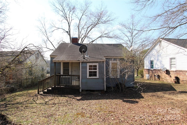 bungalow with a chimney and roof with shingles