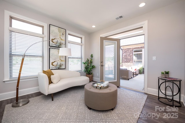 living area featuring dark wood-type flooring, recessed lighting, visible vents, and baseboards