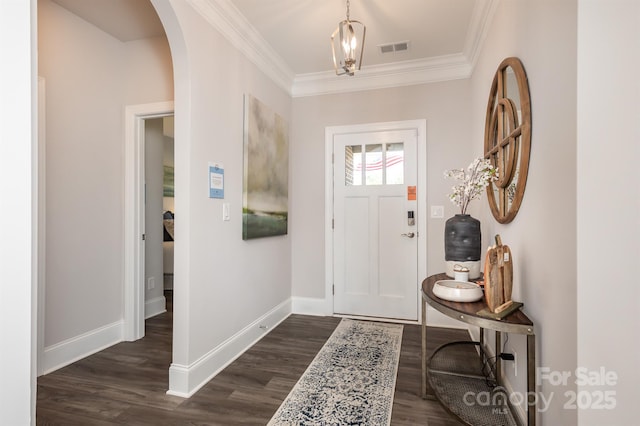 foyer with arched walkways, visible vents, baseboards, ornamental molding, and dark wood finished floors