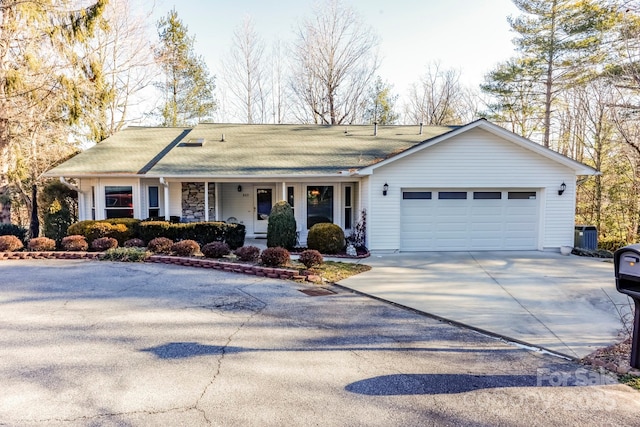 single story home with a garage, covered porch, and driveway