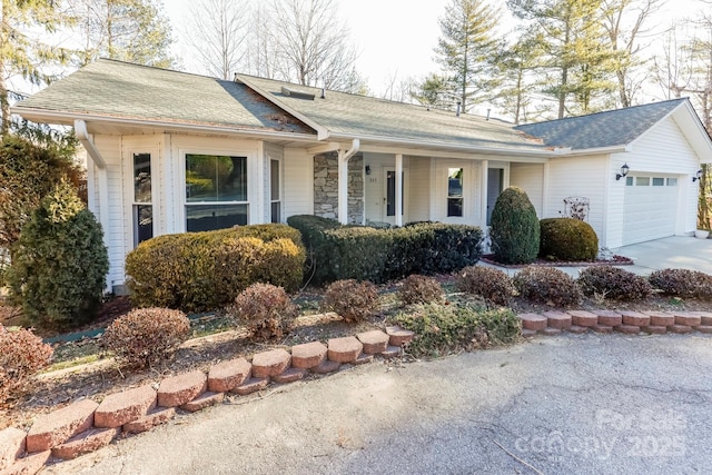 ranch-style house with a garage, stone siding, a shingled roof, and concrete driveway