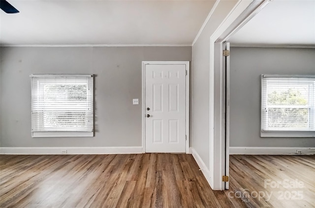 entryway with crown molding, wood finished floors, and baseboards