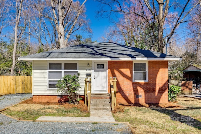 bungalow with brick siding, crawl space, and fence