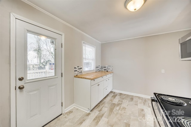 kitchen featuring black electric range, crown molding, tasteful backsplash, white cabinets, and butcher block countertops