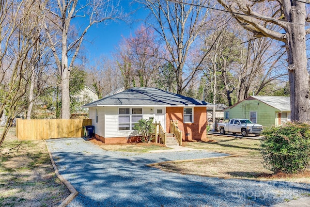 bungalow featuring driveway and fence