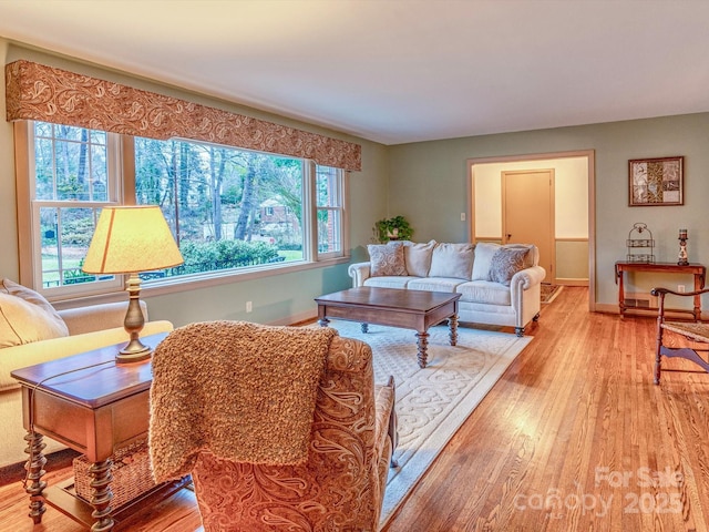 living area featuring baseboards and light wood-style floors