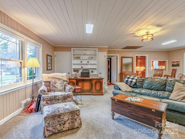 living area featuring wood walls, carpet, wooden ceiling, and crown molding