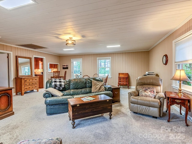 carpeted living area featuring visible vents and crown molding