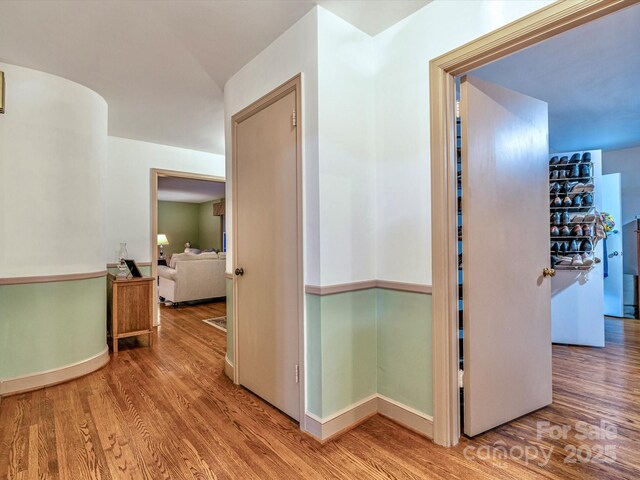 hallway featuring baseboards and wood finished floors