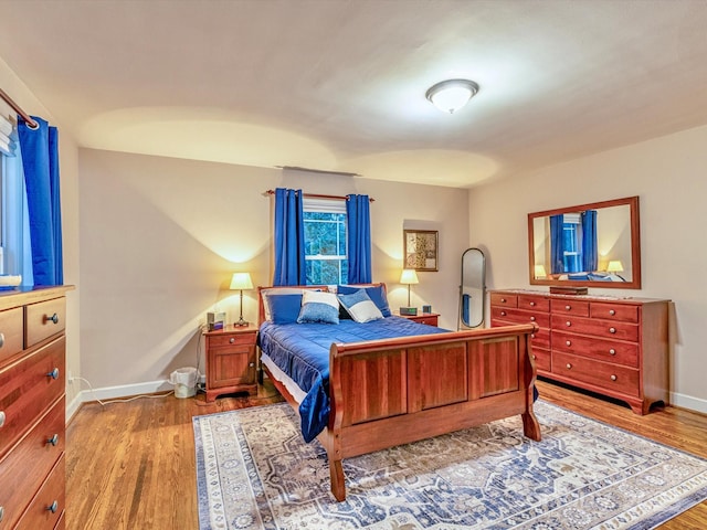 bedroom with baseboards and wood finished floors