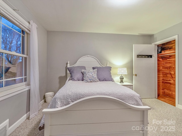 carpeted bedroom with baseboards and visible vents