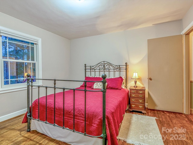 bedroom with baseboards and wood finished floors