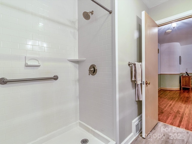 full bath featuring tiled shower and wood finished floors