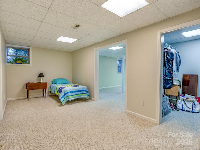 bedroom featuring a paneled ceiling, baseboards, visible vents, and carpet flooring