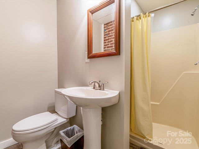 bathroom with a sink, a shower stall, and toilet