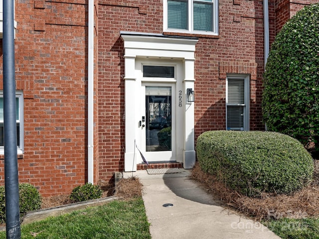 property entrance featuring brick siding