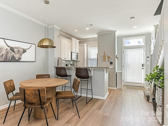 dining space with recessed lighting, visible vents, baseboards, light wood-style floors, and ornamental molding