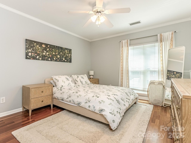 bedroom featuring visible vents, crown molding, baseboards, and wood finished floors