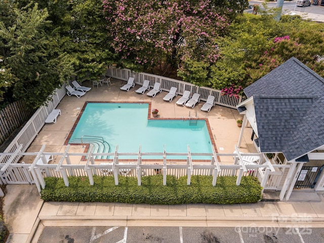 community pool featuring a patio and fence