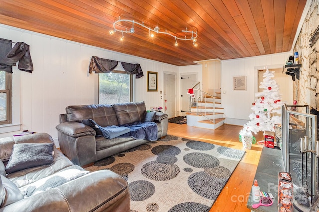 living area with wood ceiling, stairway, and wood finished floors