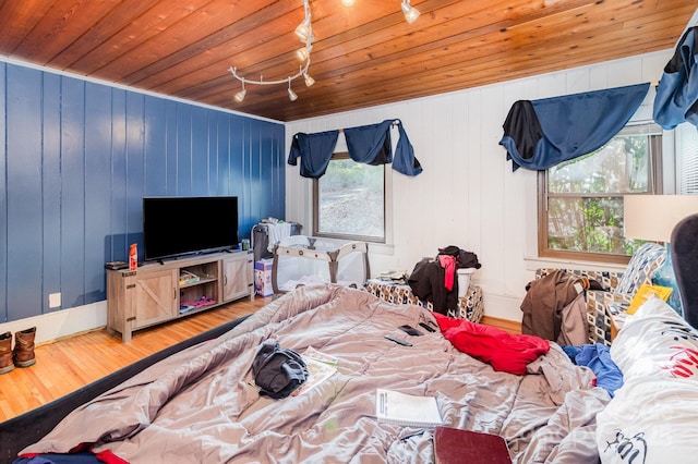 bedroom with wood ceiling, track lighting, and wood finished floors