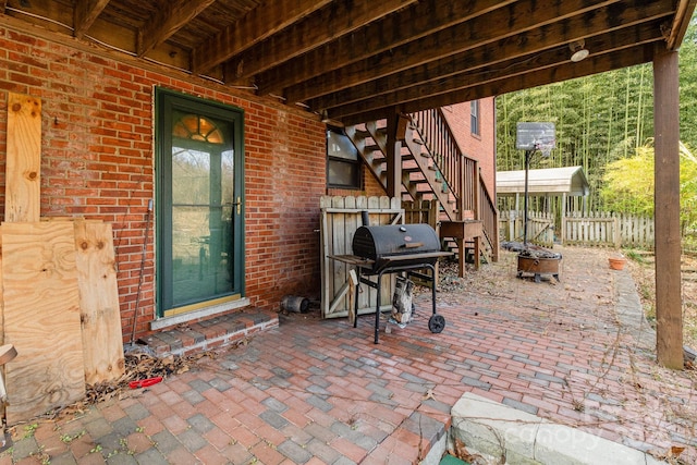 view of patio with an outdoor fire pit, stairs, fence, and area for grilling