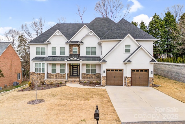 view of front of property with an attached garage, central AC, driveway, stone siding, and stucco siding