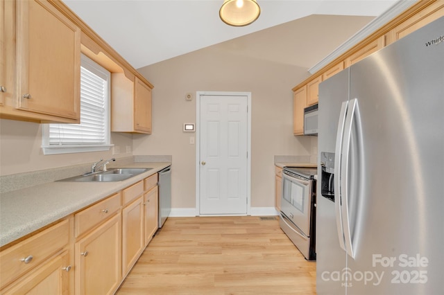 kitchen with light wood-style floors, appliances with stainless steel finishes, a sink, and light brown cabinetry