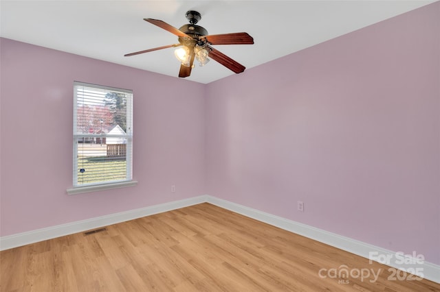 empty room with light wood-style flooring, visible vents, baseboards, and ceiling fan