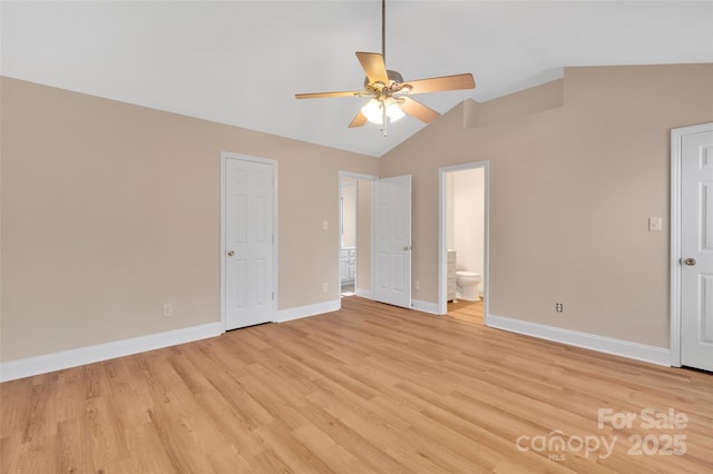 unfurnished bedroom featuring light wood finished floors, lofted ceiling, ceiling fan, ensuite bath, and baseboards