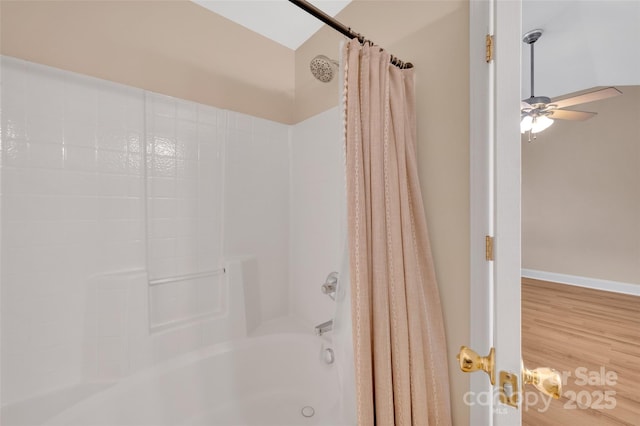 full bath with shower / tub combo, wood finished floors, a ceiling fan, and baseboards