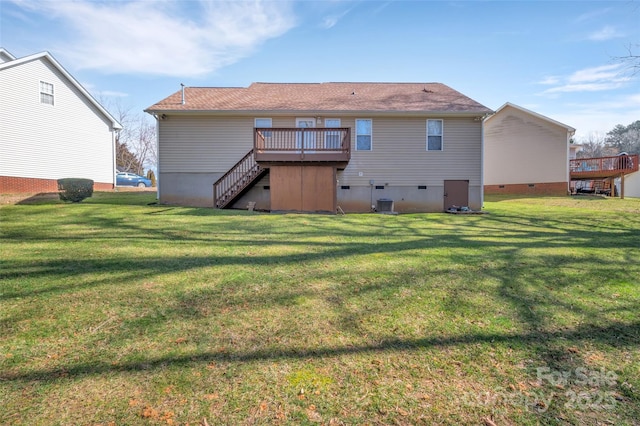 rear view of house with a deck, stairway, crawl space, and a lawn