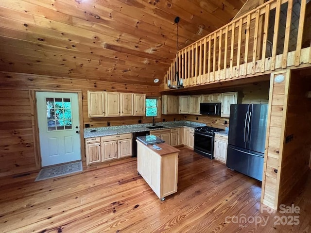 kitchen with wood ceiling, a sink, wood walls, light wood-type flooring, and black appliances