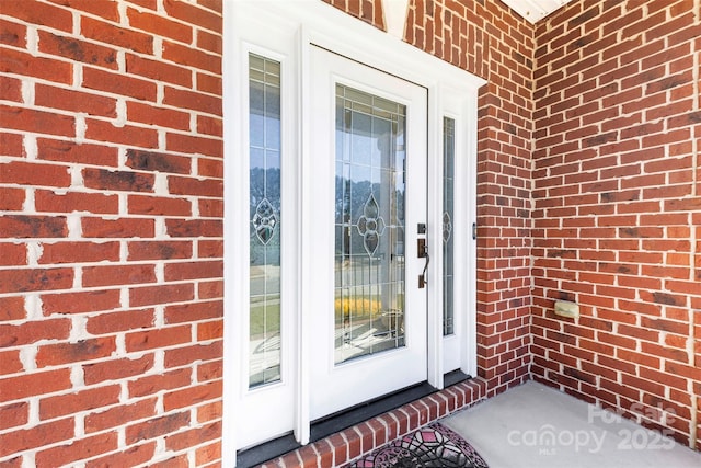 entrance to property featuring brick siding