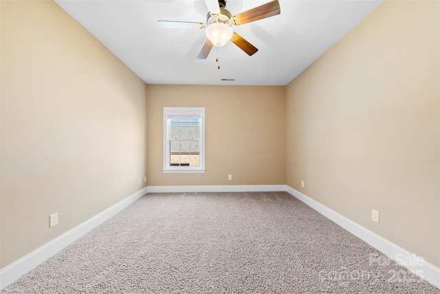 spare room featuring ceiling fan, carpet floors, visible vents, and baseboards