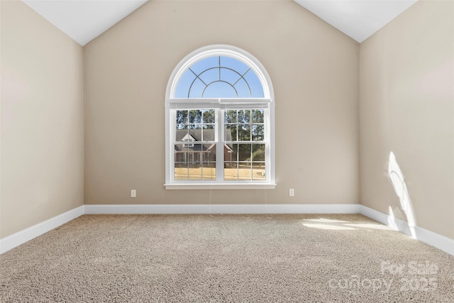 unfurnished room with lofted ceiling, carpet floors, plenty of natural light, and baseboards